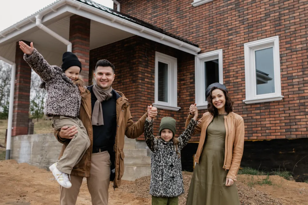Família feliz em frente de casa